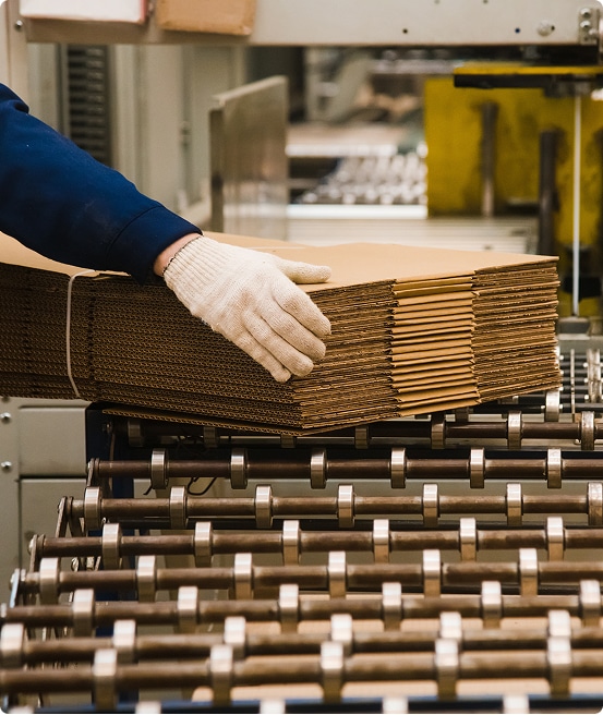 stack of unfolded boxes being handled in a warehouse